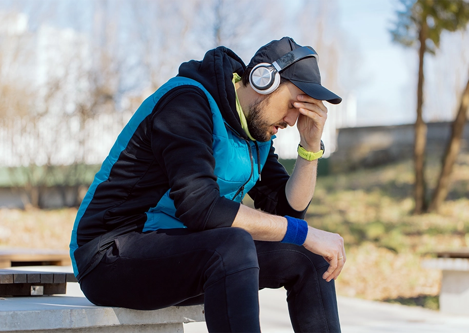 fatiqued man sitting down on park bench